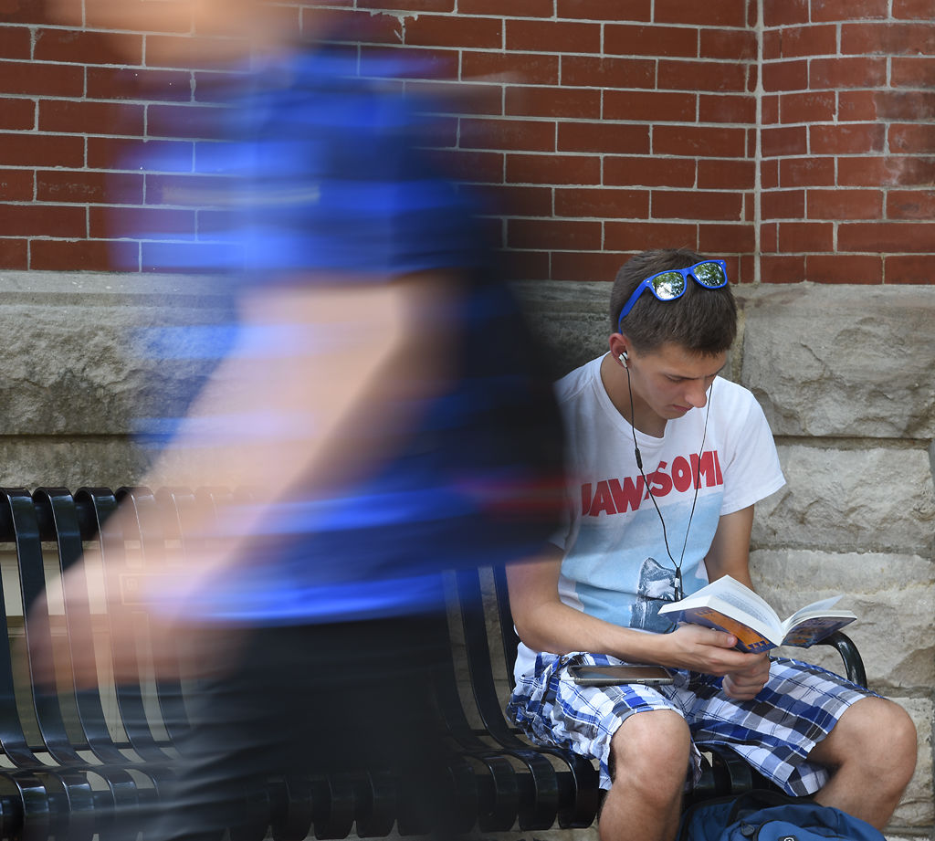 Accounting student Scott Heckman reads on a bench in front of Lafferre Hall